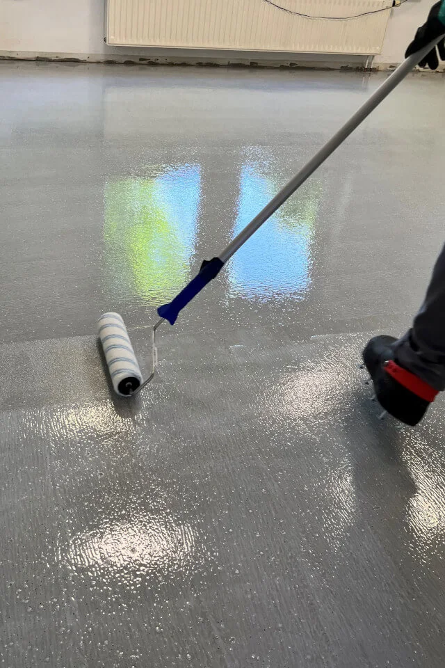 Mitarbeiter der PU Bodensanierung Krumbach versiegelt einen Boden mit einer Walze bei Sanierungsarbeiten